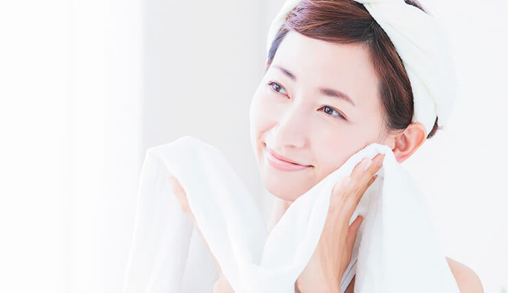 タオルで顔を拭く女性の画像