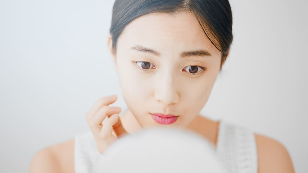 鏡を見つめる女性