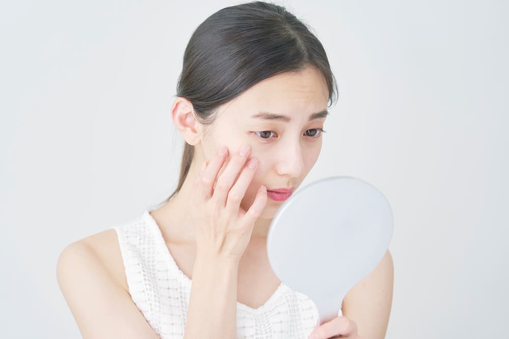 目もとを押さえる女性のイメージ